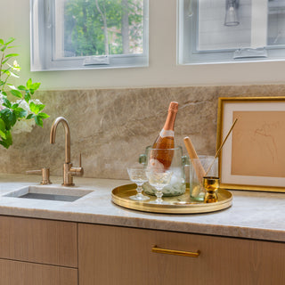 bar cart set on brass tray on counter 